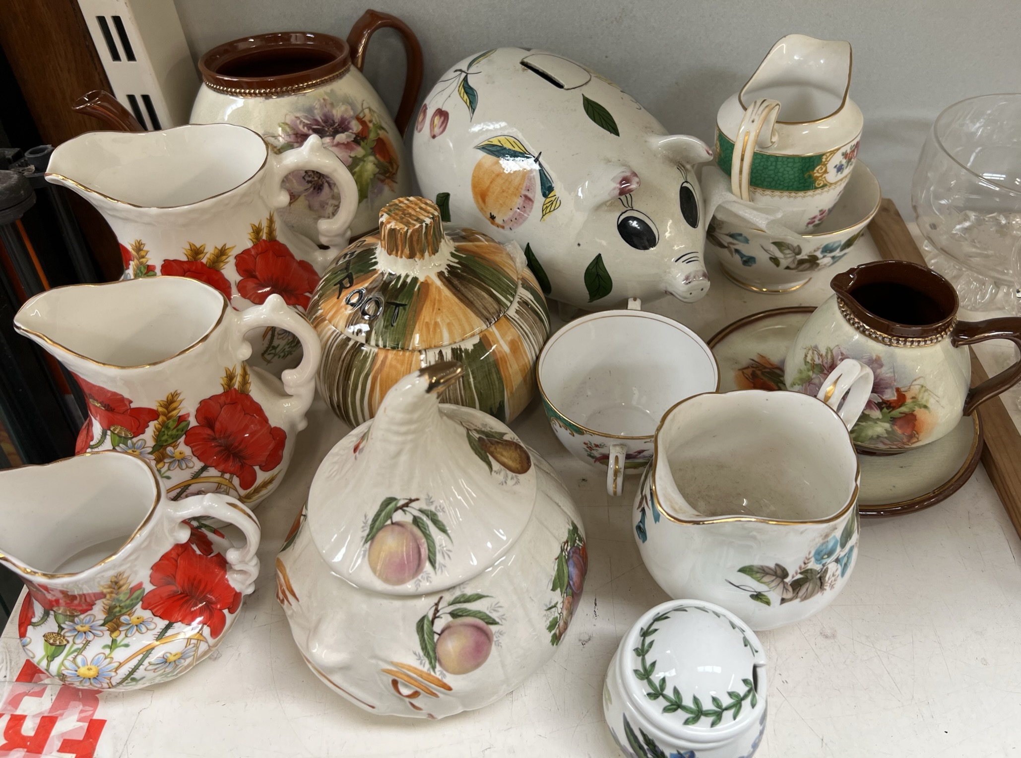 A pottery pig money box together with graduated jugs,