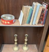 A pair of brass candlesticks together with coins,