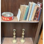 A pair of brass candlesticks together with coins,