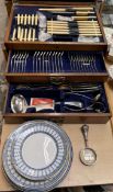 An electroplated flatware service in an oak cabinet,