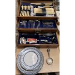 An electroplated flatware service in an oak cabinet,