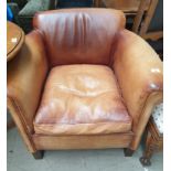 A brown leather upholstered club chair on square legs
