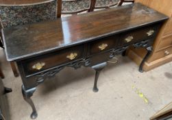 An early 20th century oak dresser base with three drawers and a pierced rail on cabriole legs and