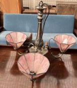 A white metal chandelier with pink glass shades