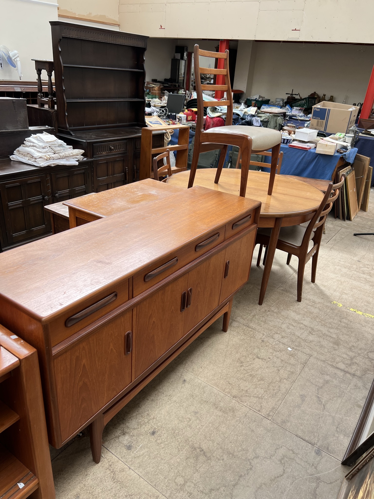A mid-20th century G-Plan teak dining suite comprising an extending dining table,