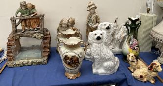 A plaster figure group of two children looking into a fish tank,