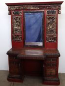 A Chinese lacquered hall stand, profusely carved with figures in a landscape with a central mirror,