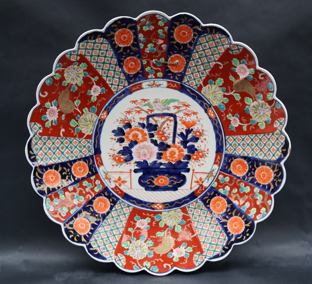 A large Japanese Imari charger decorated with radiating panels of flowers and geometric decoration,