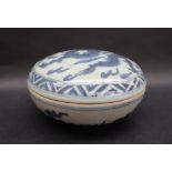 A Japanese porcelain box and cover of circular form decorated with a dragon to a chequer border,