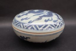 A Japanese porcelain box and cover of circular form decorated with a dragon to a chequer border,