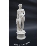 A parian figure of a naked maiden leaning on a pillar, standing on a plinth,