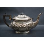 An Edward VII silver teapot of oval form embossed with flowers, leaves and scrolls, Birmingham,