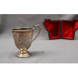 A Victorian silver Christening mug, of tapering form with scrolling decoration on a spreading foot,