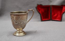 A Victorian silver Christening mug, of tapering form with scrolling decoration on a spreading foot,