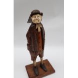 A 19th century continental carved figure, with carved bone face, tie and legs,