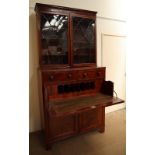 A George III mahogany secretaire bookcase, the moulded cornice above a pair of arched glazed doors,