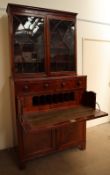 A George III mahogany secretaire bookcase, the moulded cornice above a pair of arched glazed doors,