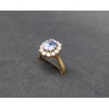 A sapphire and diamond cluster ring set with a central oval faceted sapphire,