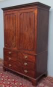 A 19th century mahogany linen press with a moulded cornice above a pair of panelled doors enclosing