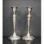 A pair of George VI silver candlesticks, with a shaped sconce and tapering body on spreading foot,