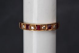 A ruby and diamond half eternity ring set with five princess cut rubies and four round brilliant