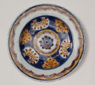 An 18th century tin glazed earthenware polychrome decorated dish, decorated with flowers and leaves,