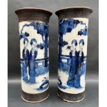 A pair of Chinese porcelain blue and white vases of cylindrical form decorated with Oriental