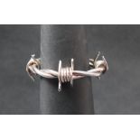 A white metal barbed wire bangle,