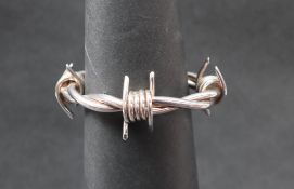 A white metal barbed wire bangle,