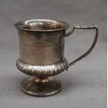 A George IV silver christening mug, with a line decorated body on a spreading foot, London 1821,