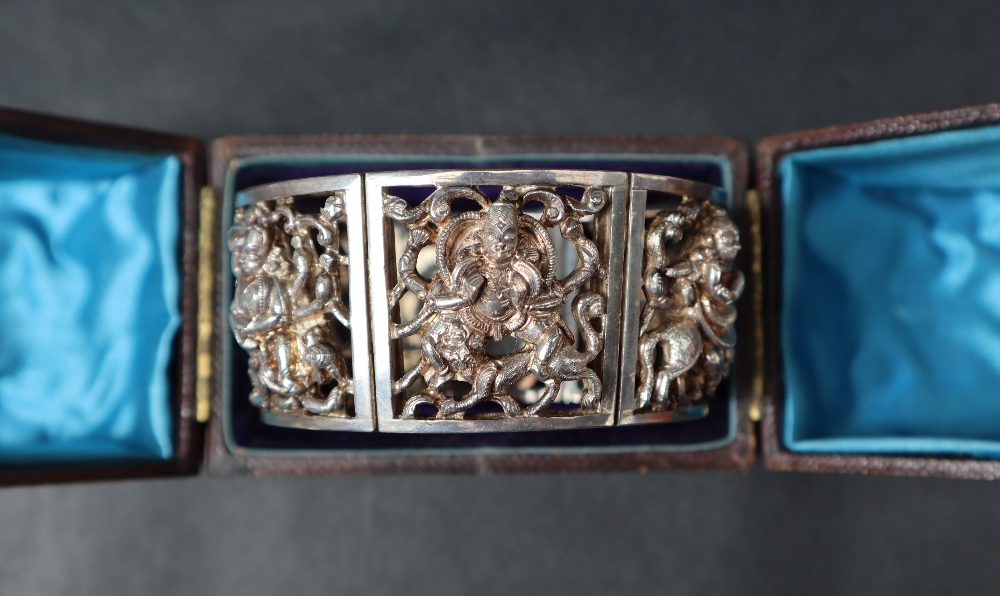 An Indian white metal bracelet comprising six panels of rectangular form depicting Indian figures