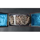 An Indian white metal bracelet comprising six panels of rectangular form depicting Indian figures