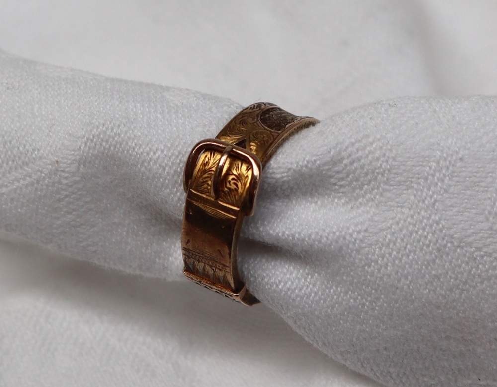 A 15ct gold buckle mourning ring with panels of plaited hair, size P,