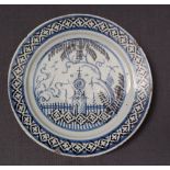 A 19th century Delft plate decorated with a church in a landscape to a lattice border,