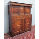 An 18th century oak court cupboard / Didarn with a moulded cornice and turned inverted finials