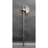 A Persian steel axe with a crescent blade decorated with stylised flowers with a spike to the top