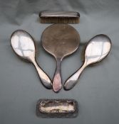 A silver backed hand mirror together with two silver backed hair brushes,