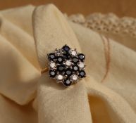 A sapphire and diamond cluster ring set with twelve round faceted sapphires and seven round