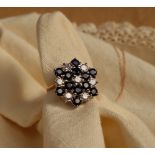 A sapphire and diamond cluster ring set with twelve round faceted sapphires and seven round