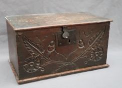 An 18th century oak deed box of rectangular form with a rectangular hinged top above a carved front,