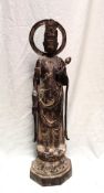 A Japanese cast iron figure of a deity holding a lotus flower on a circular base,