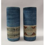 A pair of troika pottery vases of cylindrical form decorated with a band of green discs and lines,