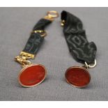A yellow metal and hardstone fob seal engraved with a coat of arms on a 9ct gold mounted silk fob