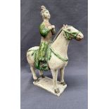 A Chinese Ming Dynasty style pottery statuette of a pony mounted by a court maiden,