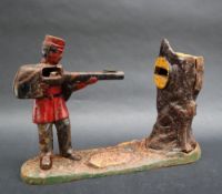 A Creedmoor cast iron money box in the form of a soldier shooting into a tree,