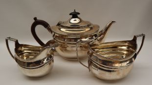 A George V three piece silver tea set, of oval form with line decoration, London, 1919, Harrods Ltd,