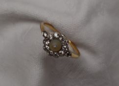 A pearl and diamond cluster ring, set with a central raised pearl,