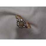 A pearl and diamond cluster ring, set with a central raised pearl,