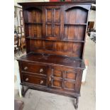 An early 20th century oak dresser, with a moulded cornice, central cupboard and shelves,