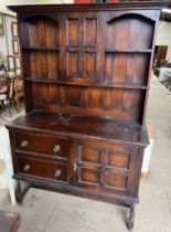 An early 20th century oak dresser, with a moulded cornice, central cupboard and shelves,